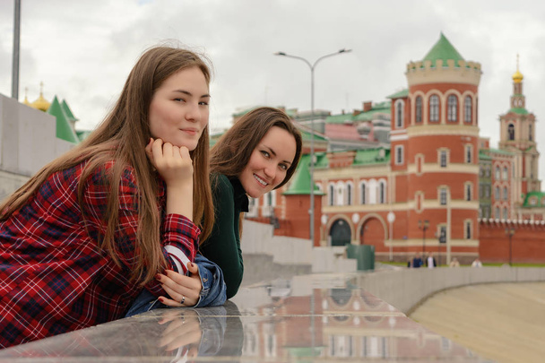 Portrait of two young women in casual wear on a walk around the city, standing and looking at the camera - Фото, зображення