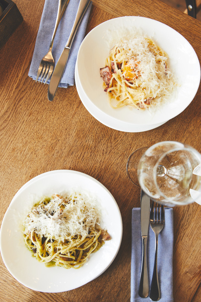 Pasta carbonara en spaghetti met paddestoelen op tafel - Foto, afbeelding