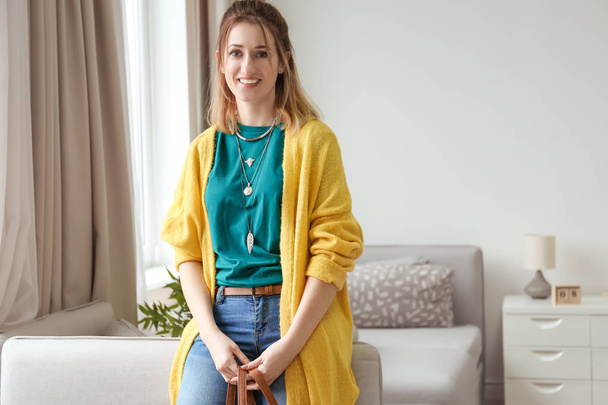 Young woman in yellow cardigan indoors - Foto, afbeelding