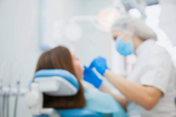 Defocused, blurred image of dentist with patient at clinic office - Foto, Bild