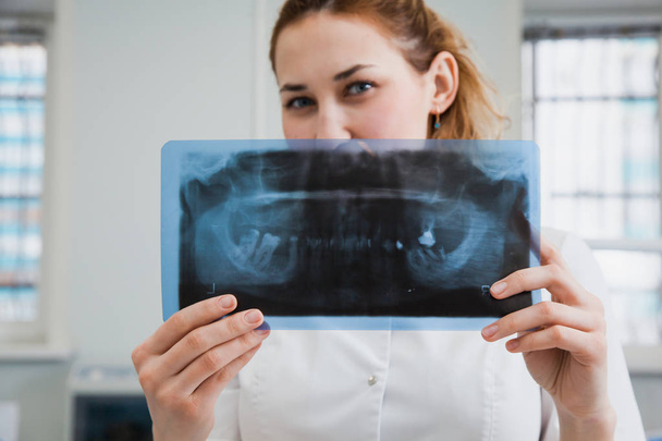 Female doctor dentist examining x-ray of human jaw - Photo, Image