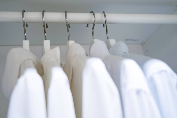 rij van mannen en vrouwen shirts op de hanger, opknoping in de kast - Foto, afbeelding