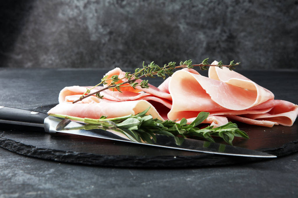 Sliced ham on stone background. Fresh prosciutto. Pork ham slice - Photo, Image
