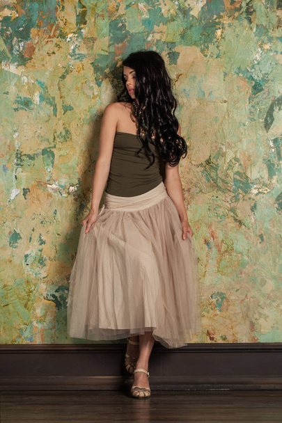 Όμορφη νεαρή γυναίκα μελαχρινή μοντέλο μόδας πράσινο τοίχο  - Φωτογραφία, εικόνα