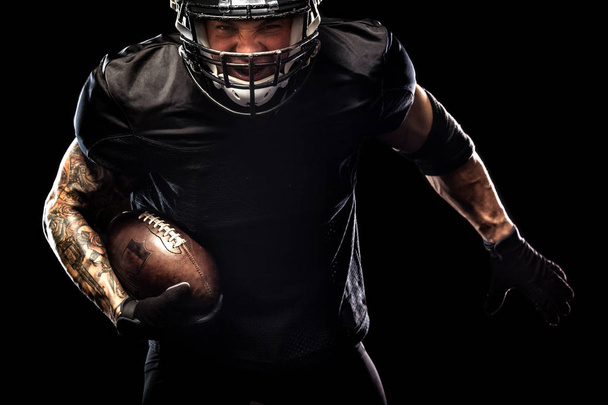 American football sportsman player isolated on black background - Valokuva, kuva