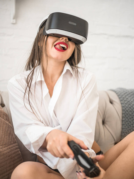 tecnología, realidad aumentada, entretenimiento y concepto de personas - mujer joven feliz con auriculares virtuales o gafas 3D jugando juego en casa
 - Foto, Imagen