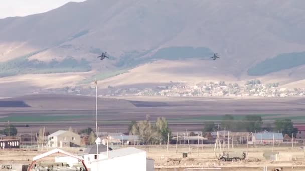 Militaire helikopters vliegen over het dorp in de bergen 2 - Video