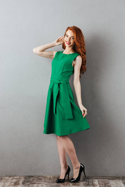 Redhead young lady in green dress. - Foto, afbeelding