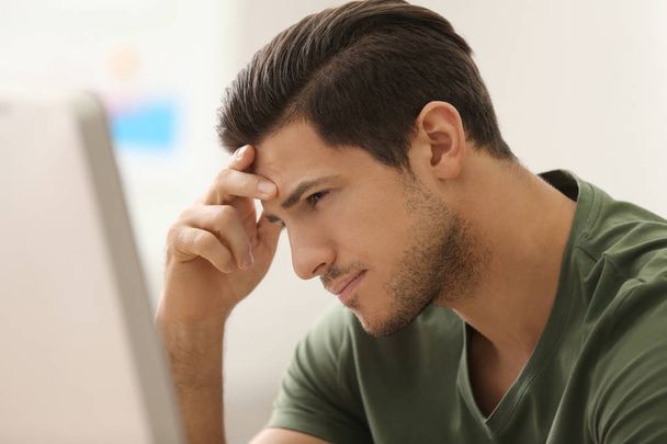 Portrait of stressed young man at workplace - Фото, зображення