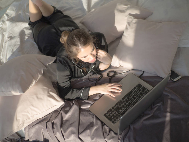 Topview closeup female with laptop on the bed - Foto, Imagem