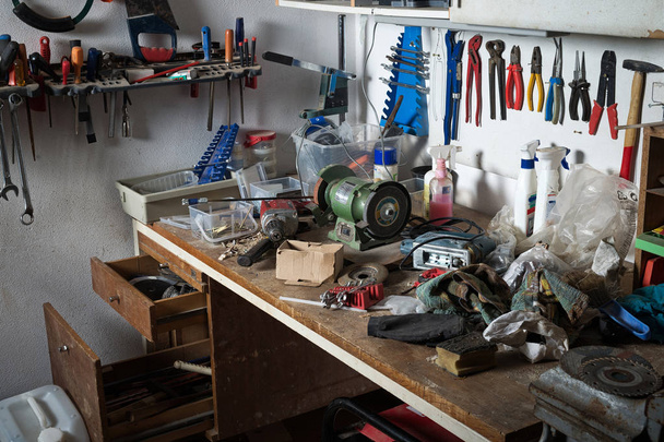 Messy workshop, complete chaos on workbench, unorganised basement or garage. Efficiency and arrangement in workshop, time to sort out mess concept. - Zdjęcie, obraz