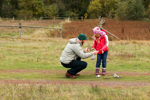 Junger Vater spielt mit seiner Tochter auf einem Feld - Foto, Bild