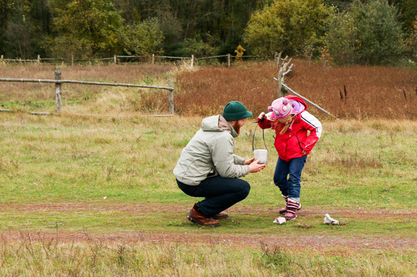 Young father playing with his daughter in a field - Foto, afbeelding