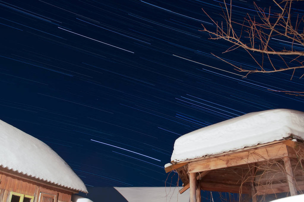 Star trail. Winter night. The roof in the snow. - Photo, Image