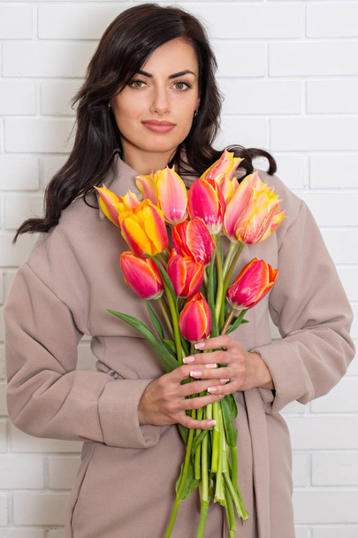 Woman in coat with bouquet - Photo, Image