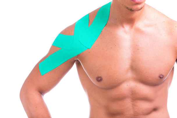Front view of a man with kinesio tape on the shoulder, isolated on a white background - Foto, Bild