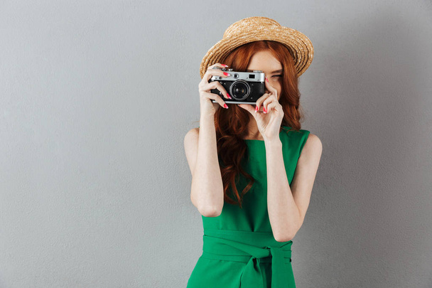 Redhead young lady photographer holding camera. - Fotografie, Obrázek