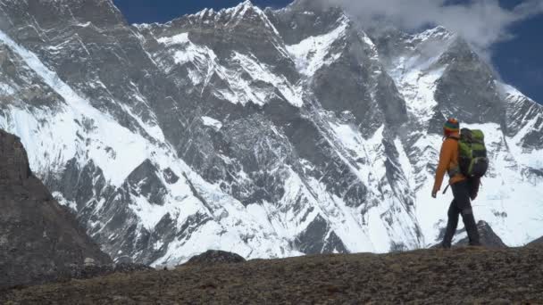 Muž s batohem lezení horského svahu v Himalájích - Záběry, video