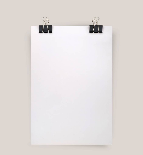Sheet of paper with binder clips isolated on a gray background - Photo, Image