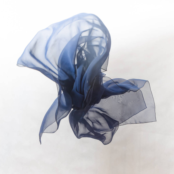 on grey background dark blue fabric in flight, texture - 写真・画像