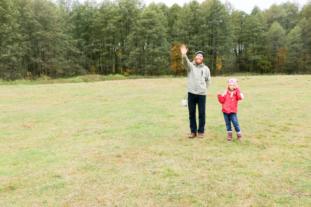 Jovem pai brincando com sua filha em um campo
 - Foto, Imagem