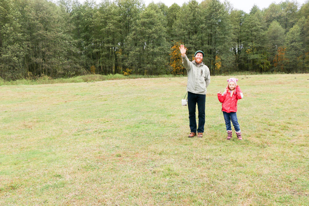 Young father playing with his daughter in a field - Foto, Imagen