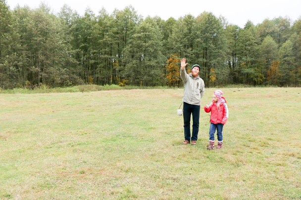 Nuori isä leikkii tyttärensä kanssa pellolla
 - Valokuva, kuva