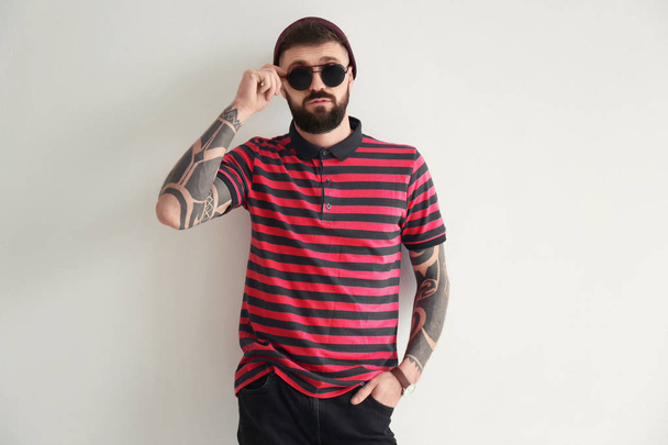 Portrait of handsome hipster in stylish outfit on light background - Foto, afbeelding