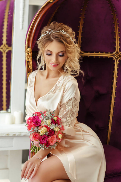 beautiful young woman in lingerie posing with bouquet on armchair - 写真・画像