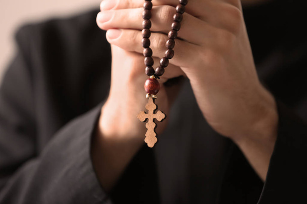 Young priest with rosary beads, closeup - Fotó, kép