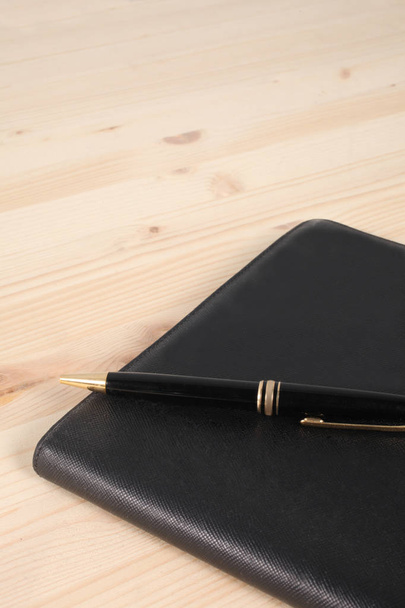 agenda con penna su una scrivania di legno - Foto, Bild