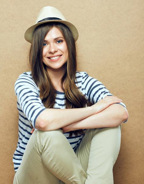 smiling woman wearing teenager style clothes sitting with crossed legs - Fotoğraf, Görsel