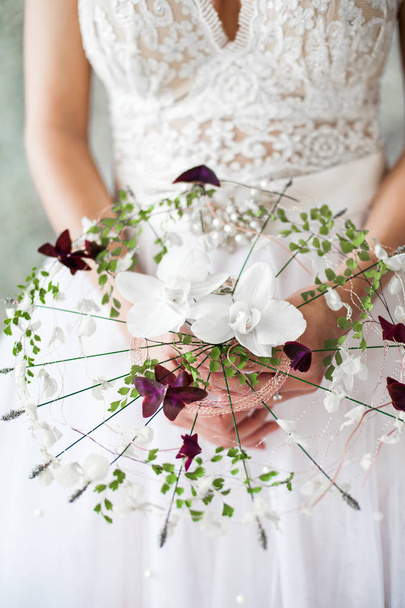 руки жінки у весільній сукні тримають букет
 - Фото, зображення