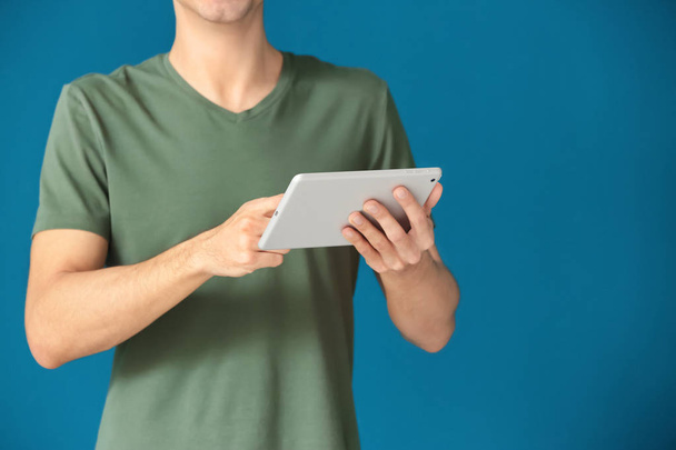 Man using tablet computer on color background - Foto, Imagem
