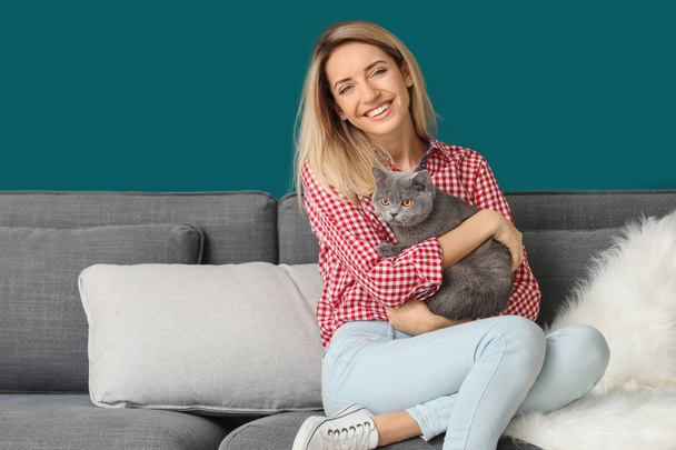 Young woman with cute pet cat at home - Fotó, kép