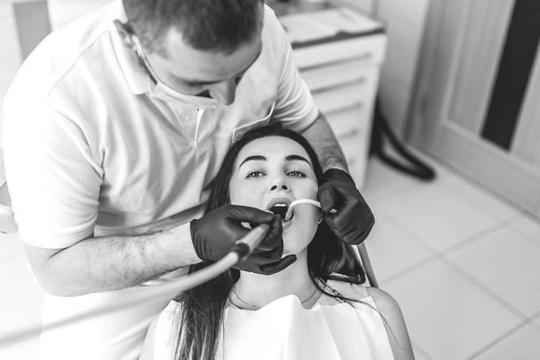 Dentist working in dental clinic with female patient in the chair - Foto, immagini