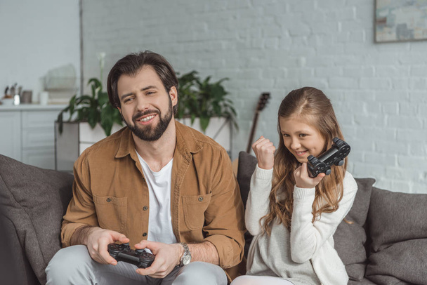 daughter winning father in video game at home - Fotografie, Obrázek