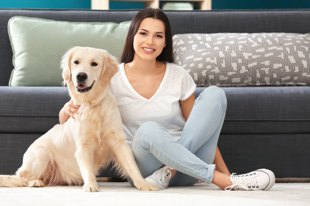 Young woman with dog indoors. Friendship between pet and owner - Foto, Imagen