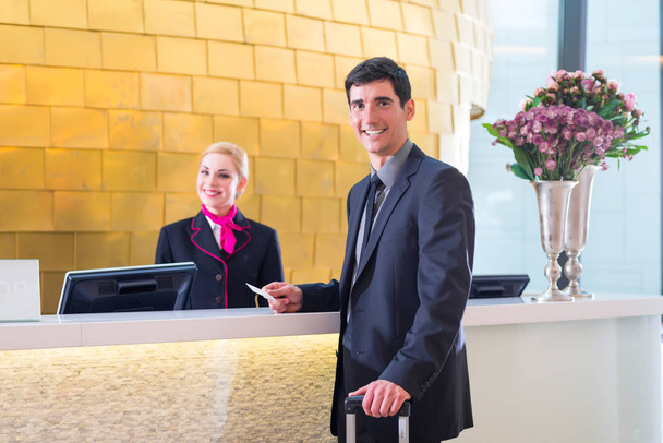 Hotel receptionist check in man giving key card - Foto, Imagen