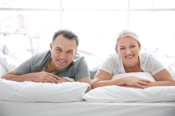 Senior couple in bed together at home - Фото, изображение