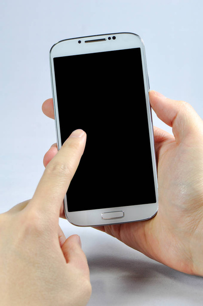 Trzymając smartfon z pustego ekranu na białym tle  - Zdjęcie, obraz