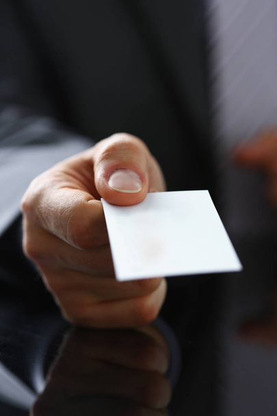 Brazo masculino en traje dar tarjeta de visita en blanco
 - Foto, Imagen