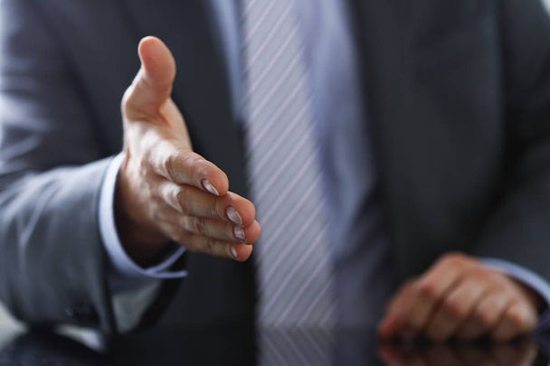 Man in pak en stropdas geven hand als hello - Foto, afbeelding