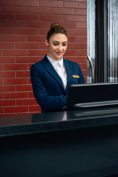 young attractive hotel receptionist using computer at workplace - Fotografie, Obrázek