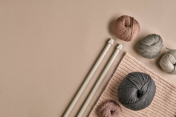 Tricotado de uma camisola de fio cinza e linha para tricotar closeup. Tricotar como passatempo. Acessórios para tricô
. - Foto, Imagem