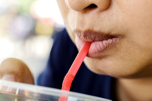 Крупный план рот азиатской женщины с питьевой водой с всасывающей трубкой
. - Фото, изображение