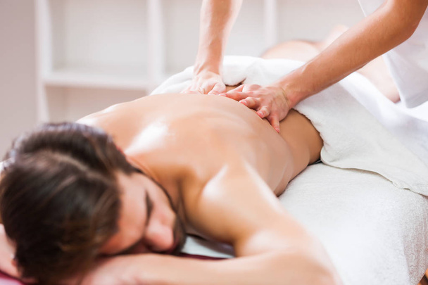 Young man is enjoying massage on spa treatment.  - Fotografie, Obrázek