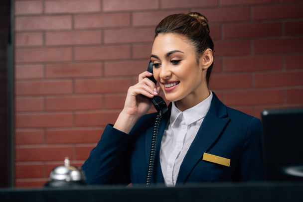fiatal gyönyörű szállodai recepciós hívást a munkahelyen - Fotó, kép