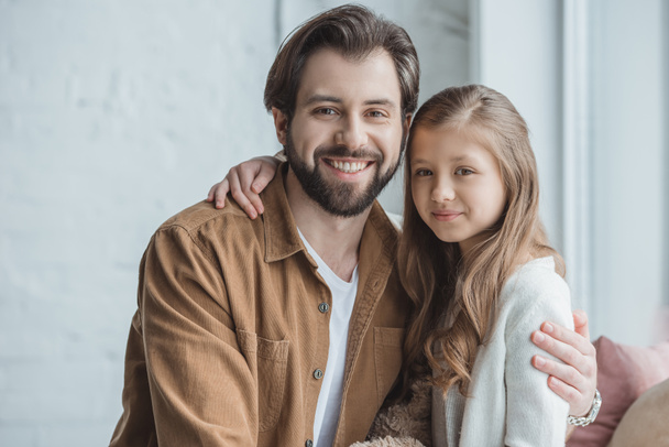 happy father and daughter looking at camera at home  - Фото, изображение