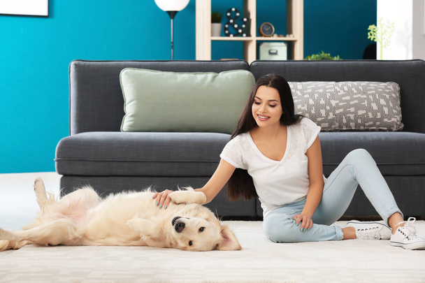 Young woman with dog indoors. Friendship between pet and owner - Foto, imagen